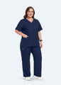 Navy StyleFlex™ Plus Size women's scrub top with matching scrub pants, full-length view by COMENII